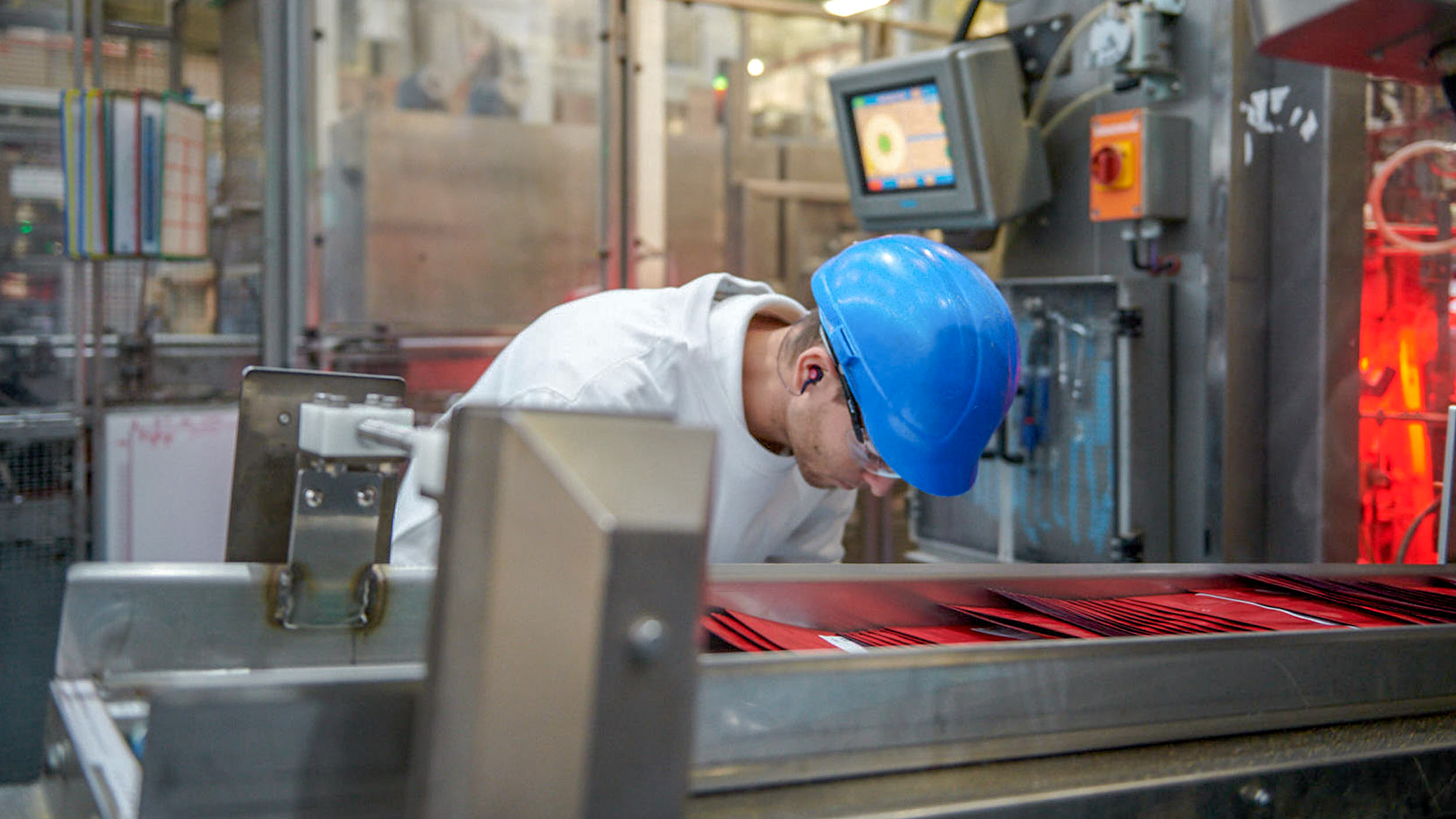 A man in a factory checking the quality of packaging