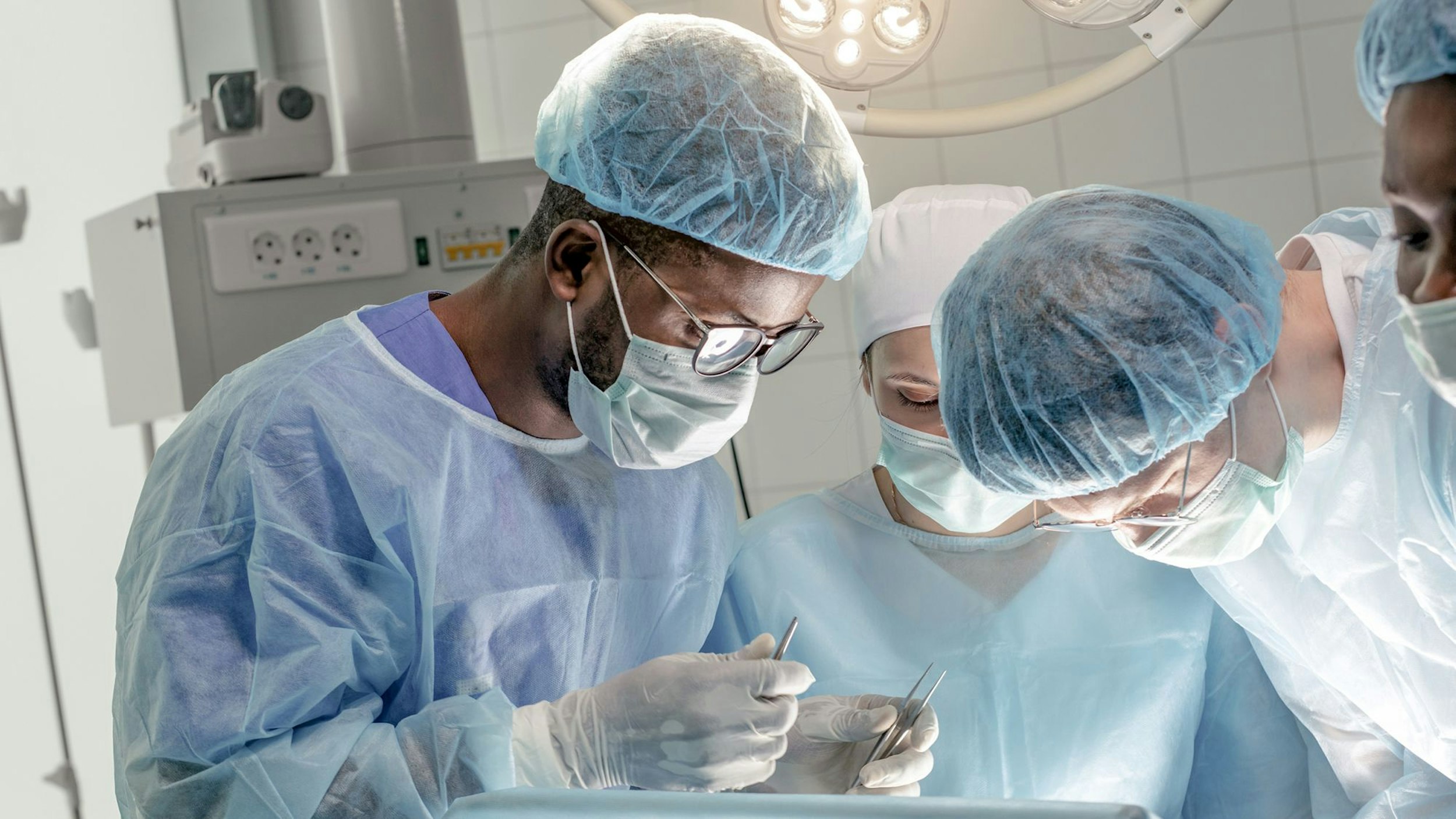Grup de medici la masa de operație