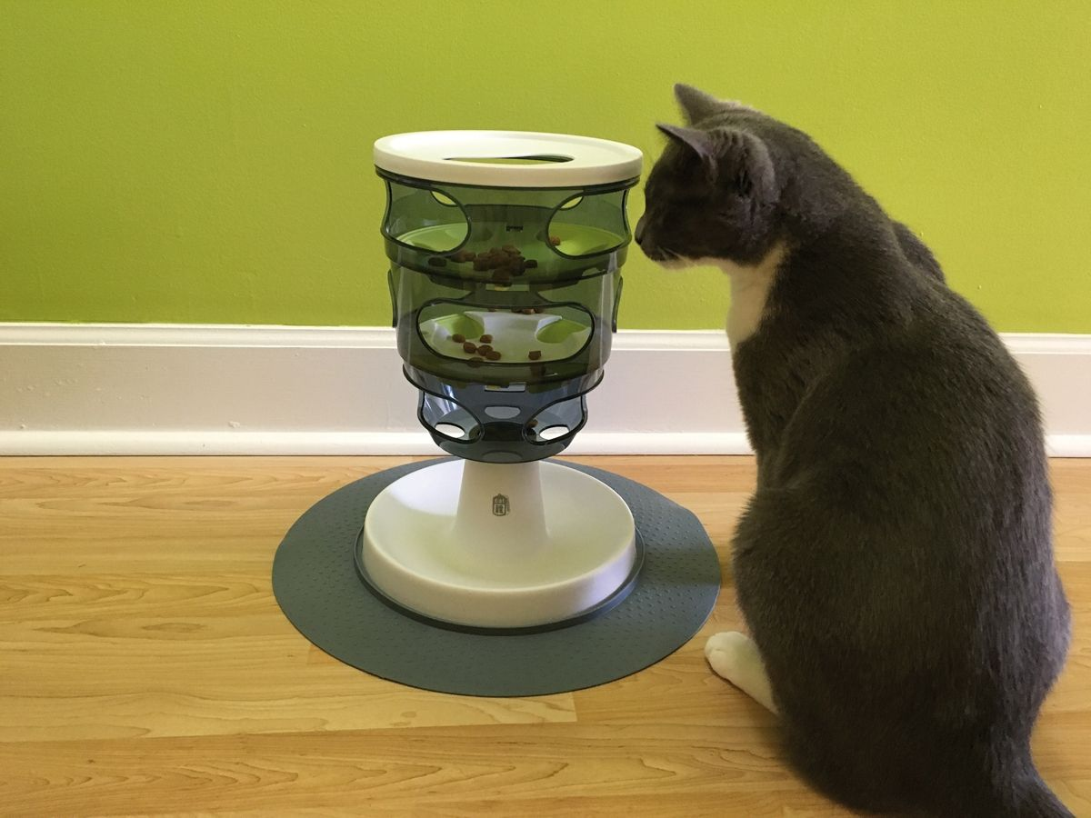 This stationary tower requires a cat to move food down through various levels using its paws before it can eat the kibble.